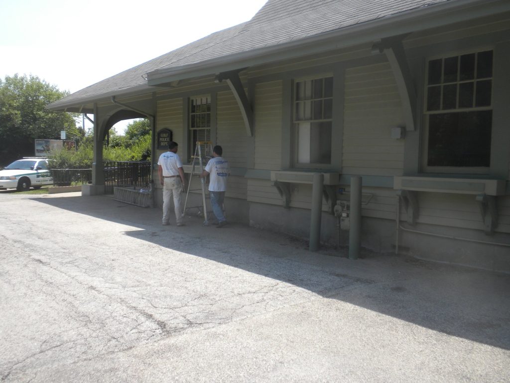 Crew painting the columns of the Golf Metra station