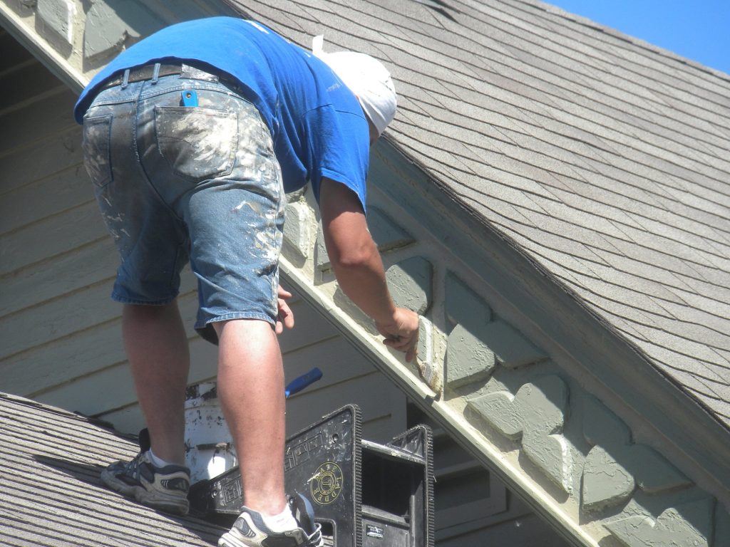 Painter brushing the fascia of the Golf Metra station