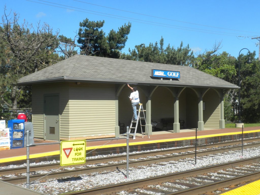 Painter on a ladder at the Golf Metra station