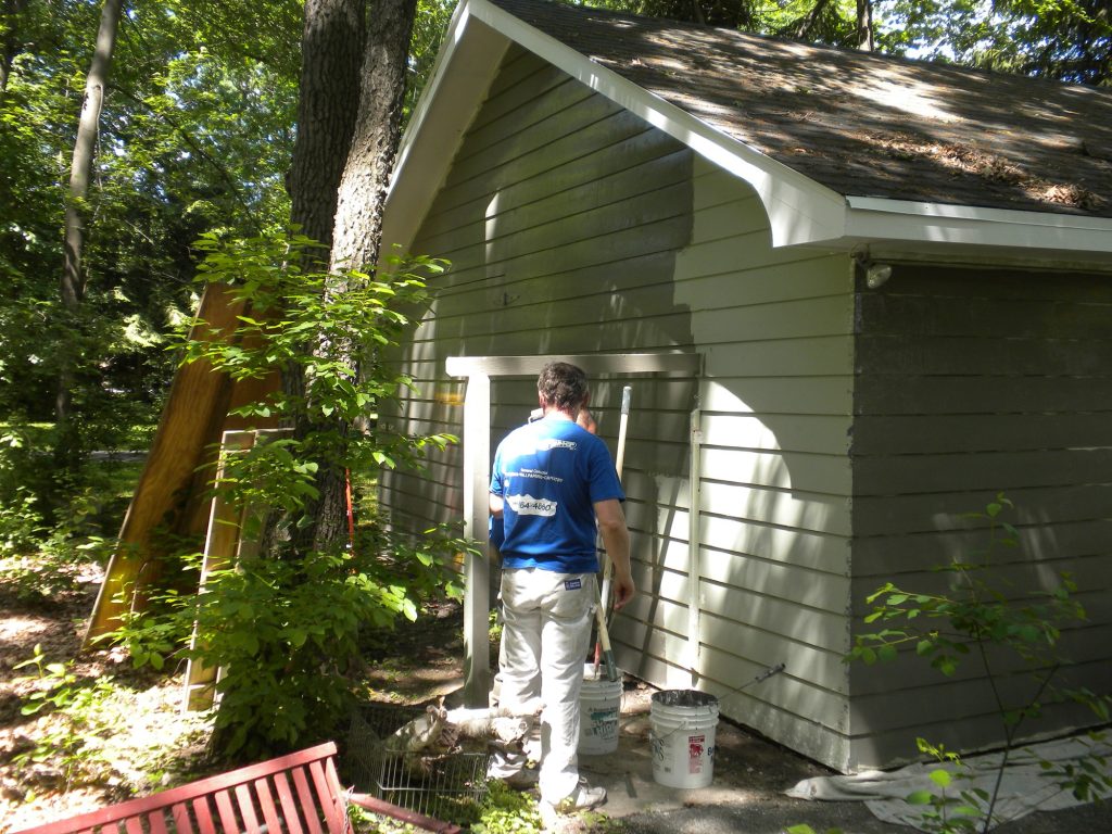 Painter working on the garage side wall at the Green Lake lake house