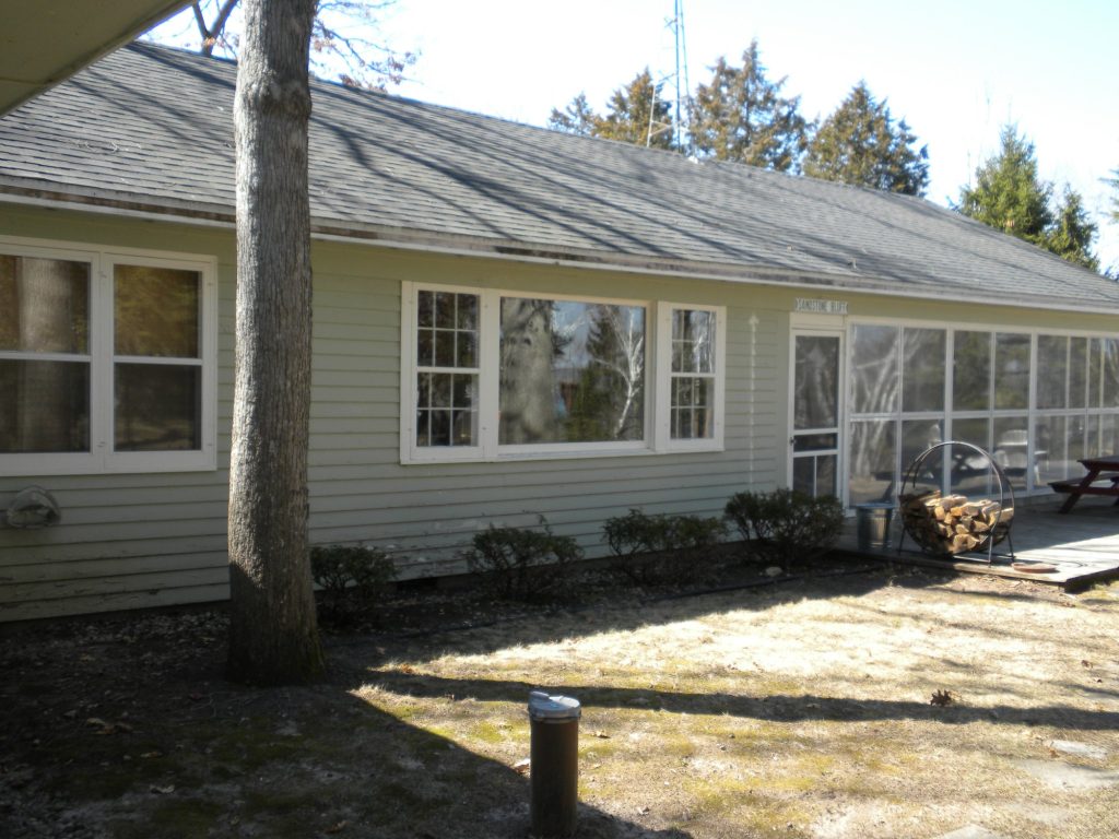 Lake house in Green Lake, Wisconsin before painting: faded siding, faded corner