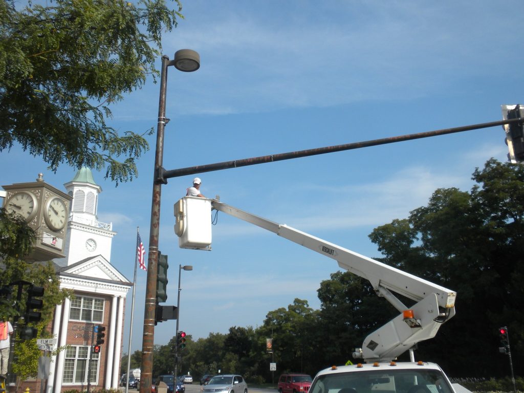 Bucket truck painting a light pole near the Winnetka clock tower