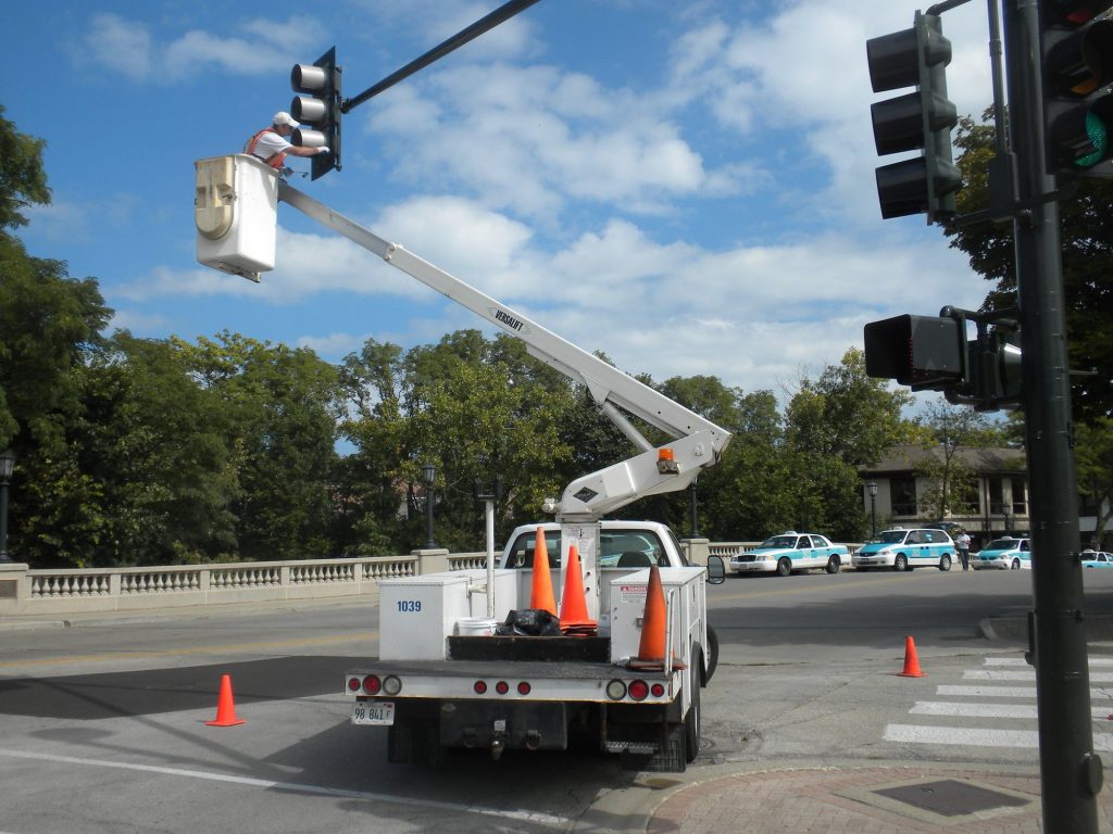 Painter working on a Winnetka street light pole from a bucket truck